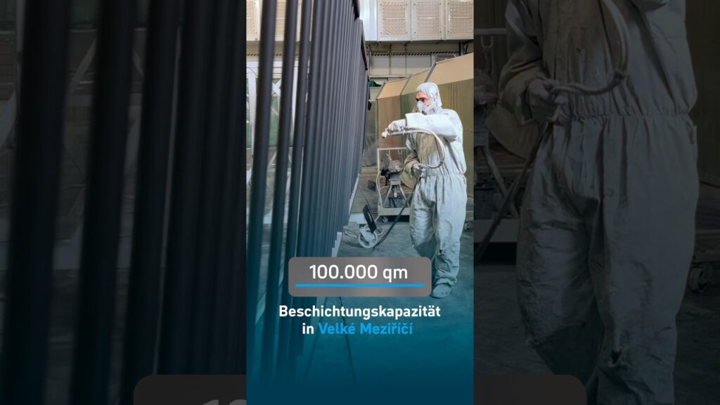 Beschichter im Schutzanzug lackiert Stahlteile im WIEGEL-Werk Velké Meziříčí – Standbild aus dem Reel, eingeblendet „100.000 qm Beschichtungskapazität“
